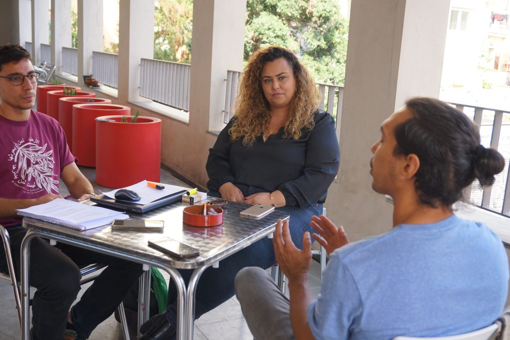 Dues joves colombianes explicant la seva experiència al tècnic de Justícia Global del CJB
